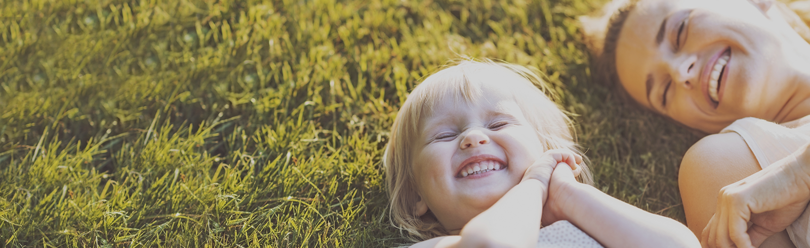 woman and child laying in grass