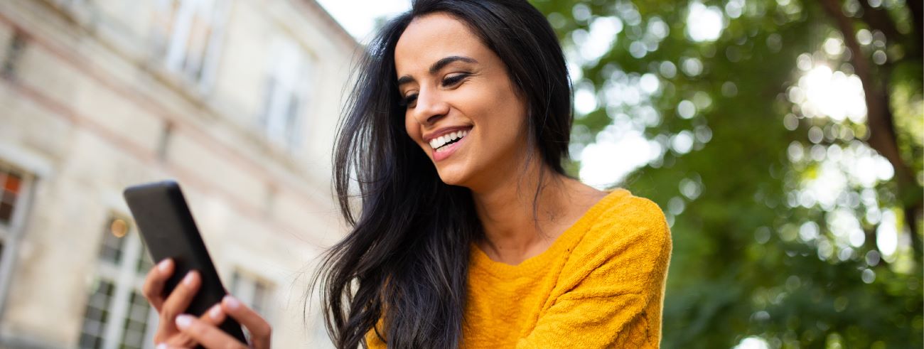 A woman happily looking at her phone